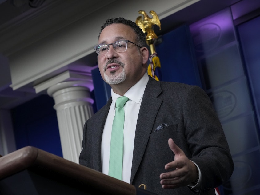 caption: U.S. Education Secretary Miguel Cardona speaks at a March briefing at the White House.