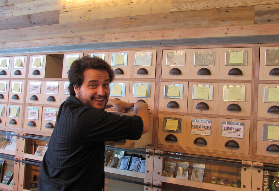 caption: Ben Perez works behind the counter at the new Dockside SODO marijuana retail store.