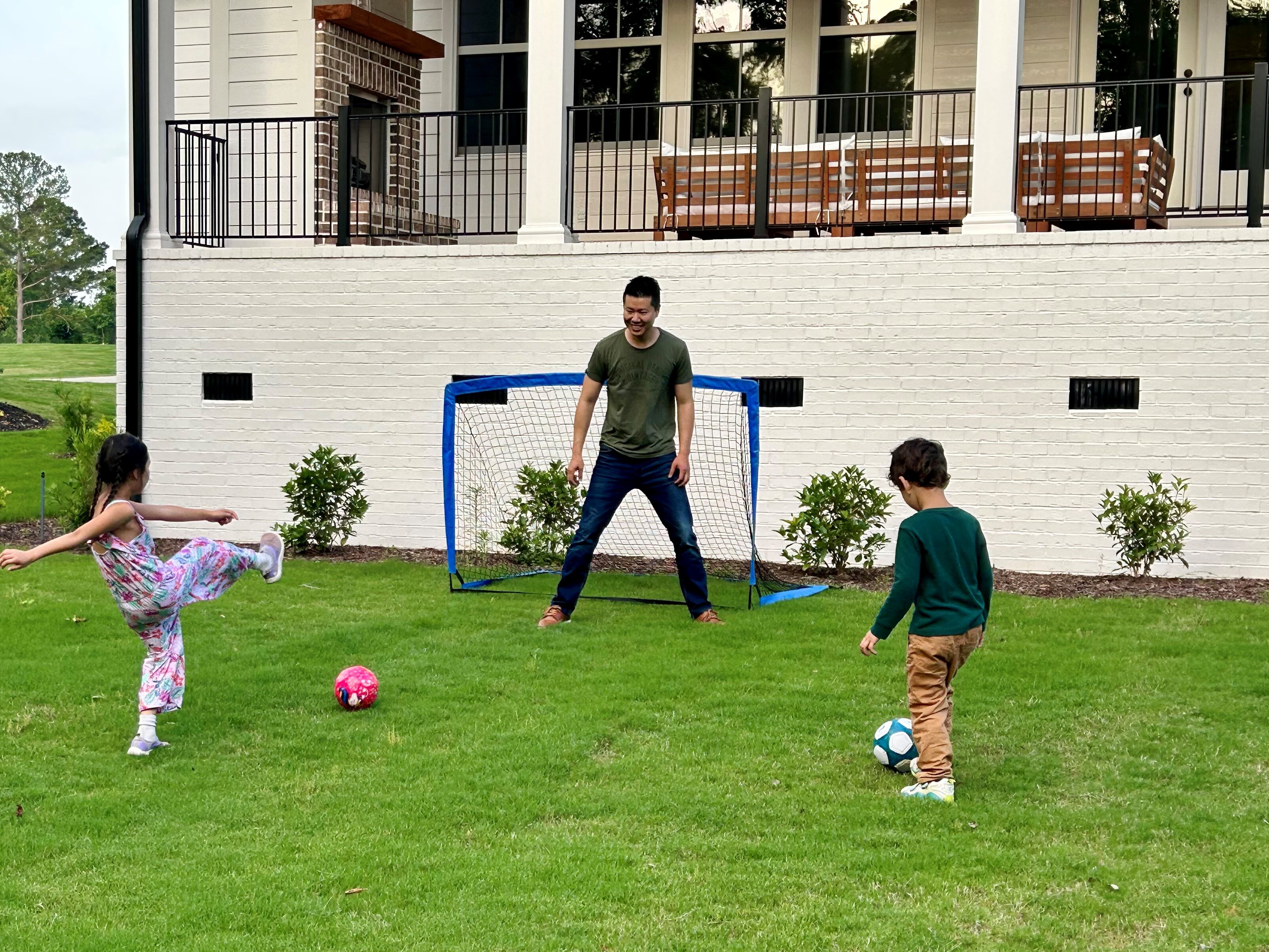 caption: Jim Xiao paid an agent a flat $10,000 fee to help him buy a home in Evans, Ga., last year. Here, Xiao and his children play soccer at their new home.
