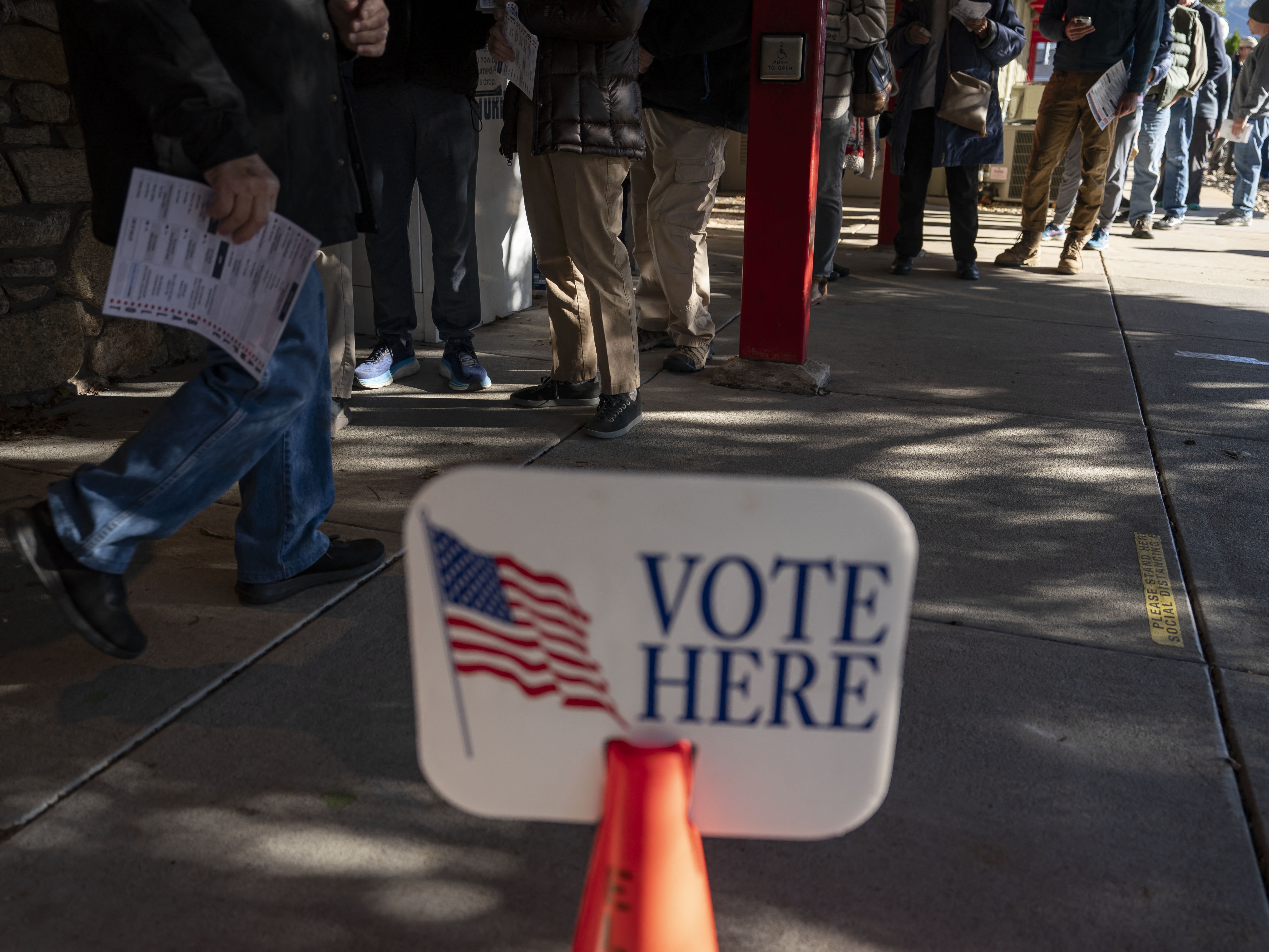 caption: People wait in line to cast ballots during early voting at a polling station in Black Mountain, North Carolina, on Friday.