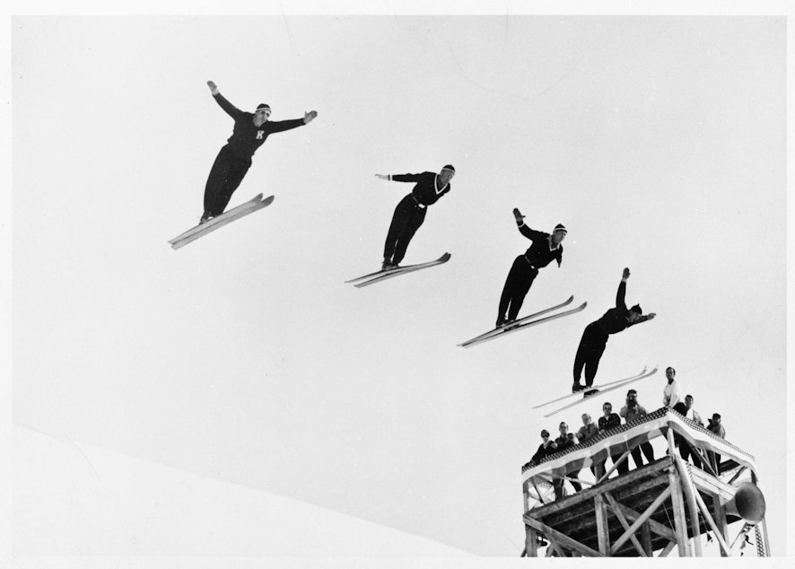 caption: Olav Ulland, Gustav Raaum, Alf Engen, and Kjell Stordalen perform a four-person simultaneous ski jump at Sun Valley, Idaho, in December 1948.