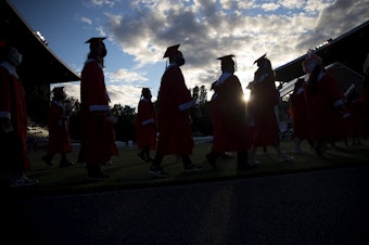caption: Seattle seniors graduate on Tuesday, June 15, 2021, during an in-person commencement ceremony at Memorial Stadium in Seattle.
