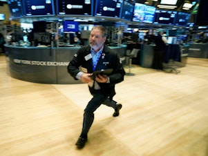 caption: Traders work on the floor of the New York Stock Exchange in New York City on Tuesday. Stocks tumbled on Wednesday amid fears that worries about the banking system were widening to other parts of the world.
