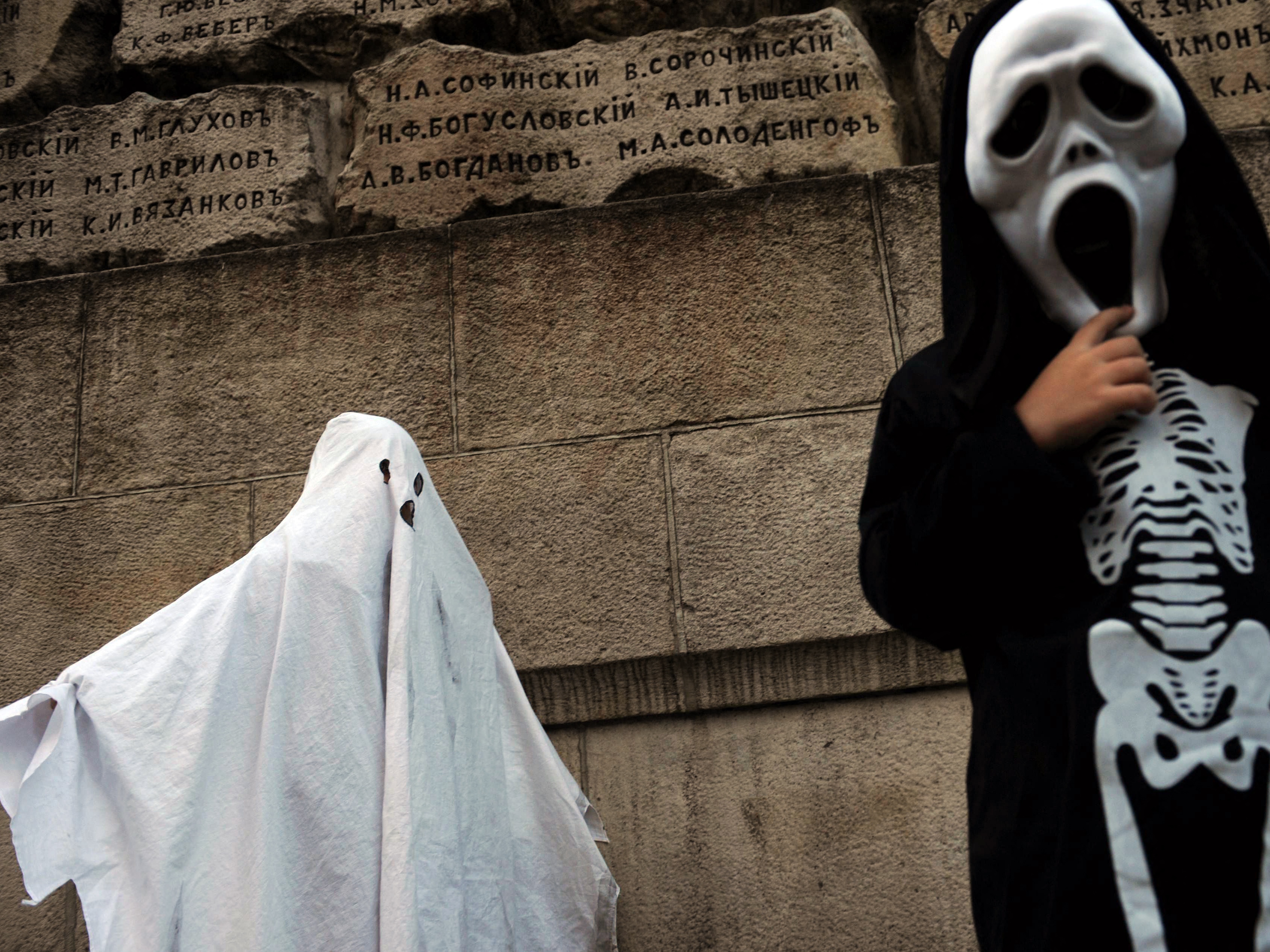 caption: Two children, one of whom is dressed as a ghost, attend a Halloween party in Sofia, Bulgaria, in 2010.