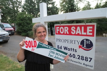 caption: Natalie Johnson in front of her new home. 
