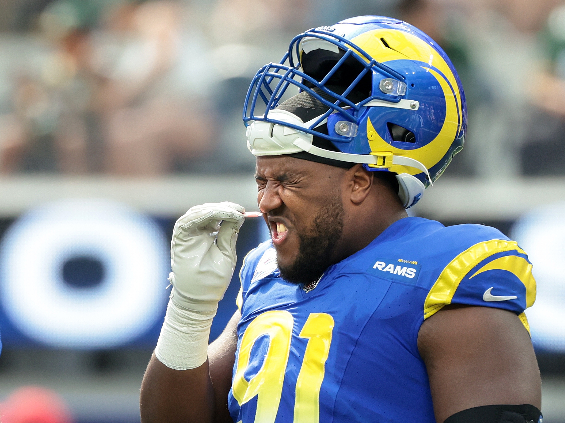 caption: Rams defensive end Kobie Turner takes a sniff of smelling salts during a game against the Packers at SoFi Stadium in Inglewood on Sunday. The NFL has banned use of the substance for safety reasons.