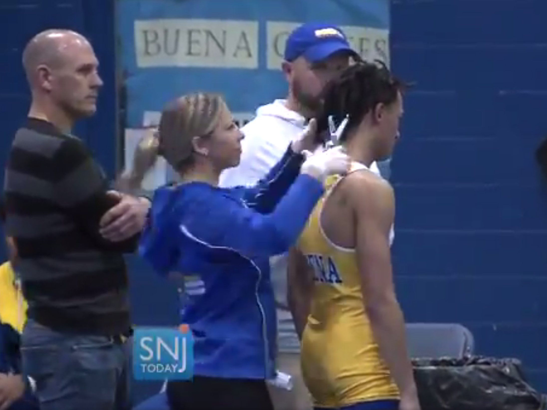 caption: A video still shows Buena Regional High School wrestler Andrew Johnson getting his hair cut on Dec. 19, in Buena, N.J., after referee Alan Maloney told Johnson he would forfeit the match if he did not have his dreadlocks cut.