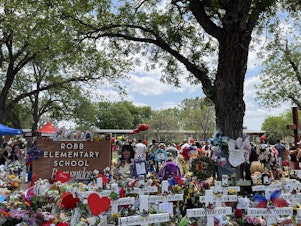 caption: The trees that George Garza planted as a new teacher in the 1960s today offer shade at the memorial to the victims of the mass shooting at Robb Elementary School in Uvalde, Texas.