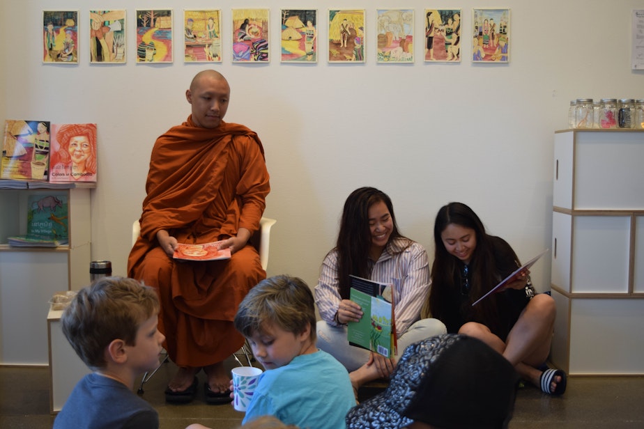 caption: Venerable Prenz and two members of the University of Washington Khmer Student Association, Melissa Ouk and Molica Perry, prepare for a bilingual book reading of “Colors of Cambodia” in Khmer and English.