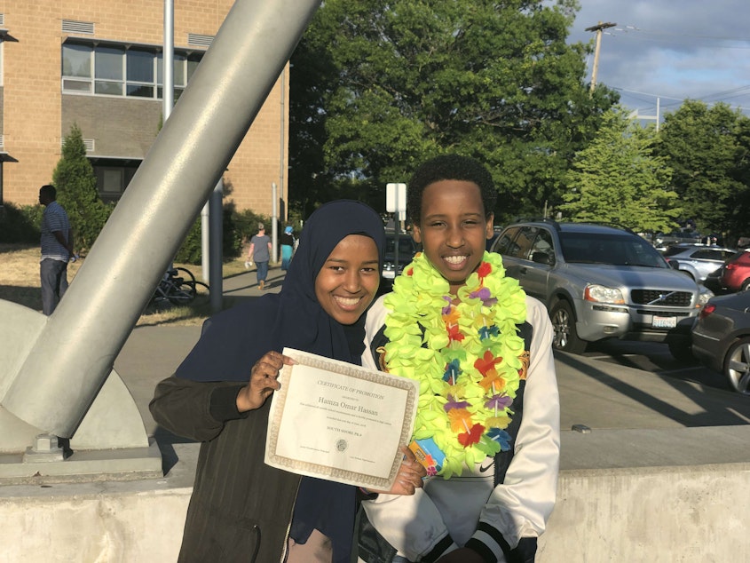 caption: Hamda Hassan poses with her little brother at his 8th grade graduation. Hamda wants to be a role model for her brother.