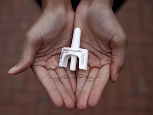 In this Jan. 23, 2018 photo, Leah Hill, a behavioral health fellow with the Baltimore City Health Department, displays a sample of Narcan nasal spray in Baltimore. Public health officials say the drug is a critical tool in addressing America's opioid epidemic. (AP Photo/Patrick Semansky)