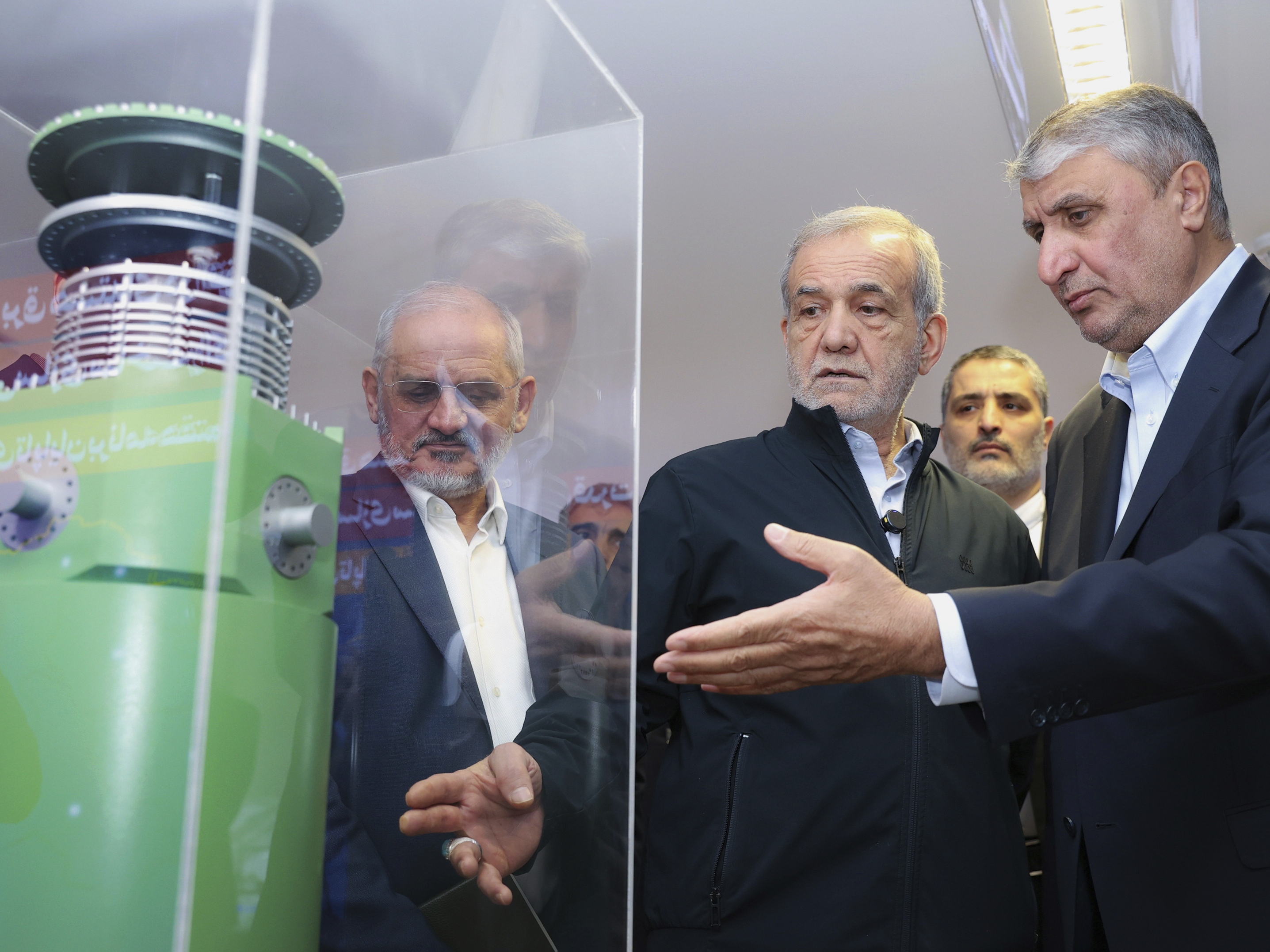 caption: Iranian President Masoud Pezeshkian (second right) listens to the director of the Atomic Energy Organization of Iran, Mohammad Eslami, as he visits an exhibition of Iran's nuclear achievements in Tehran, Iran, April 9.