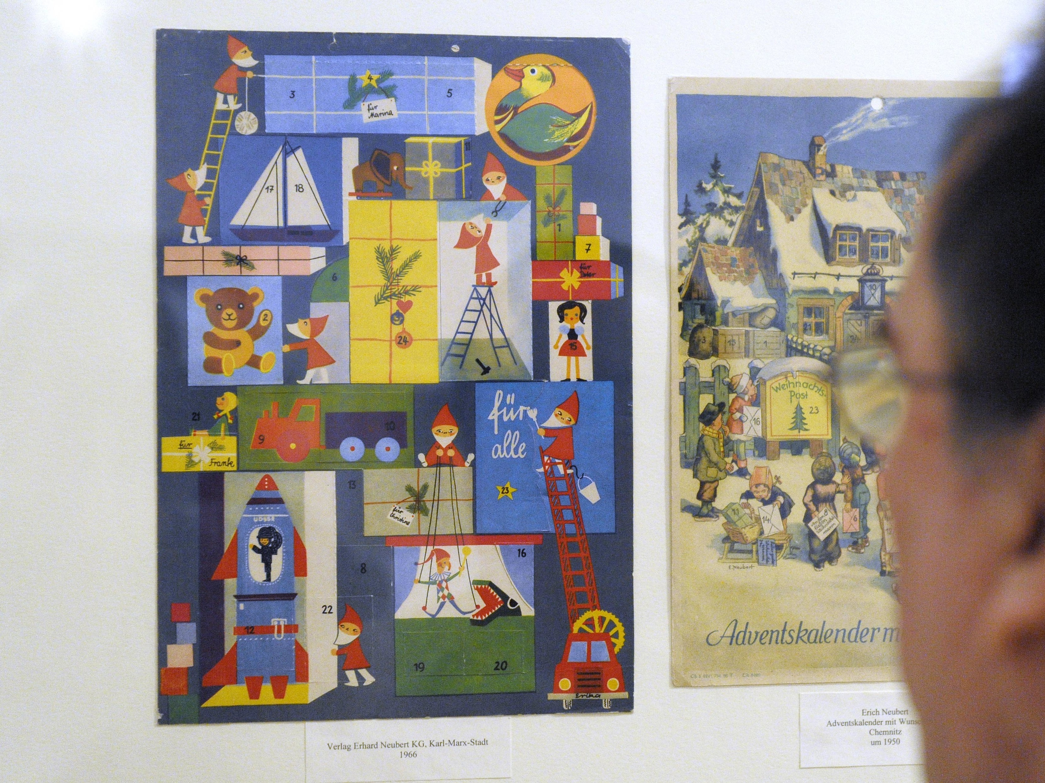 caption: A visitor looks at an Advent calendar from 1966 of the former East Germany at a 2008 museum exhibit in Leipzig.