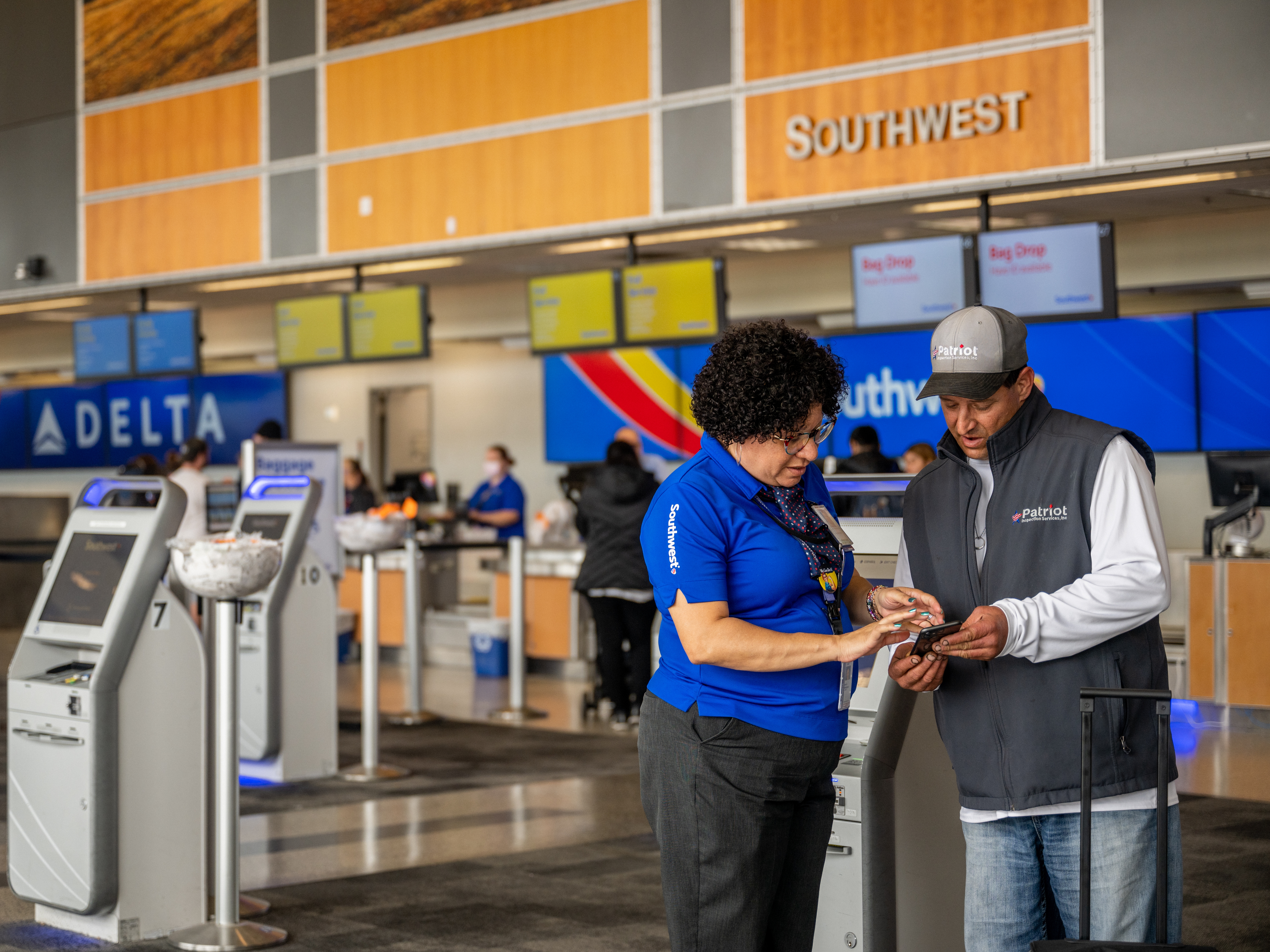 caption: Southwest Airlines unveiled big shifts in how it does business Thursday, saying it will throw out the open-seating model it has used for decades and introduce redeye flights. Here, an employee and passenger are seen at the Austin-Bergstrom International Airport last year in Austin, Texas.