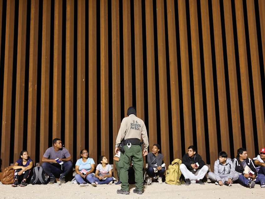 caption: A border patrol agent speaks to people who were apprehended in Yuma, Arizona on May 11 a the U.S. border as Title 42 expired. The agency said on Wednesday that an 8-year-old girl died after being detained.