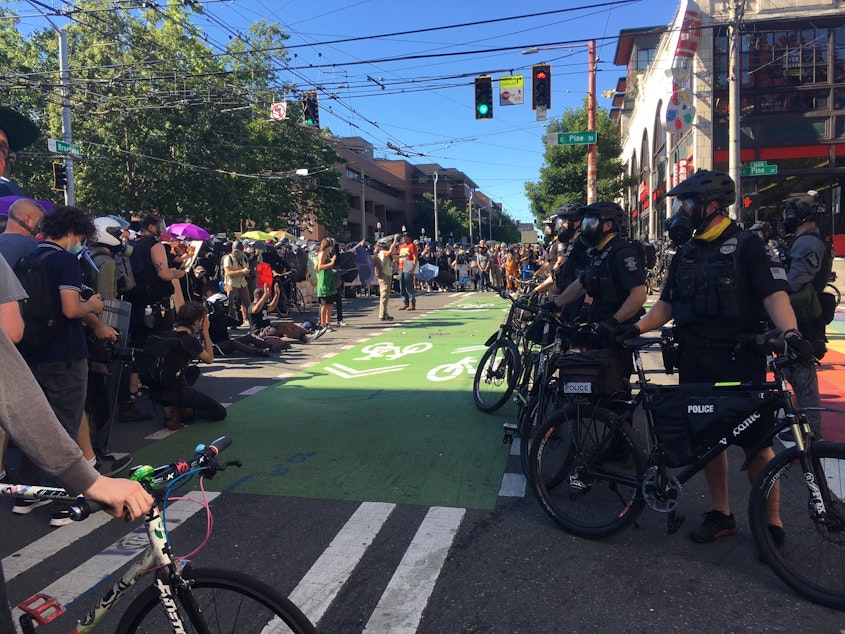 caption: Police officers face off with people protesting onSeattle's Capitol Hill on Saturday, July 25 2020.