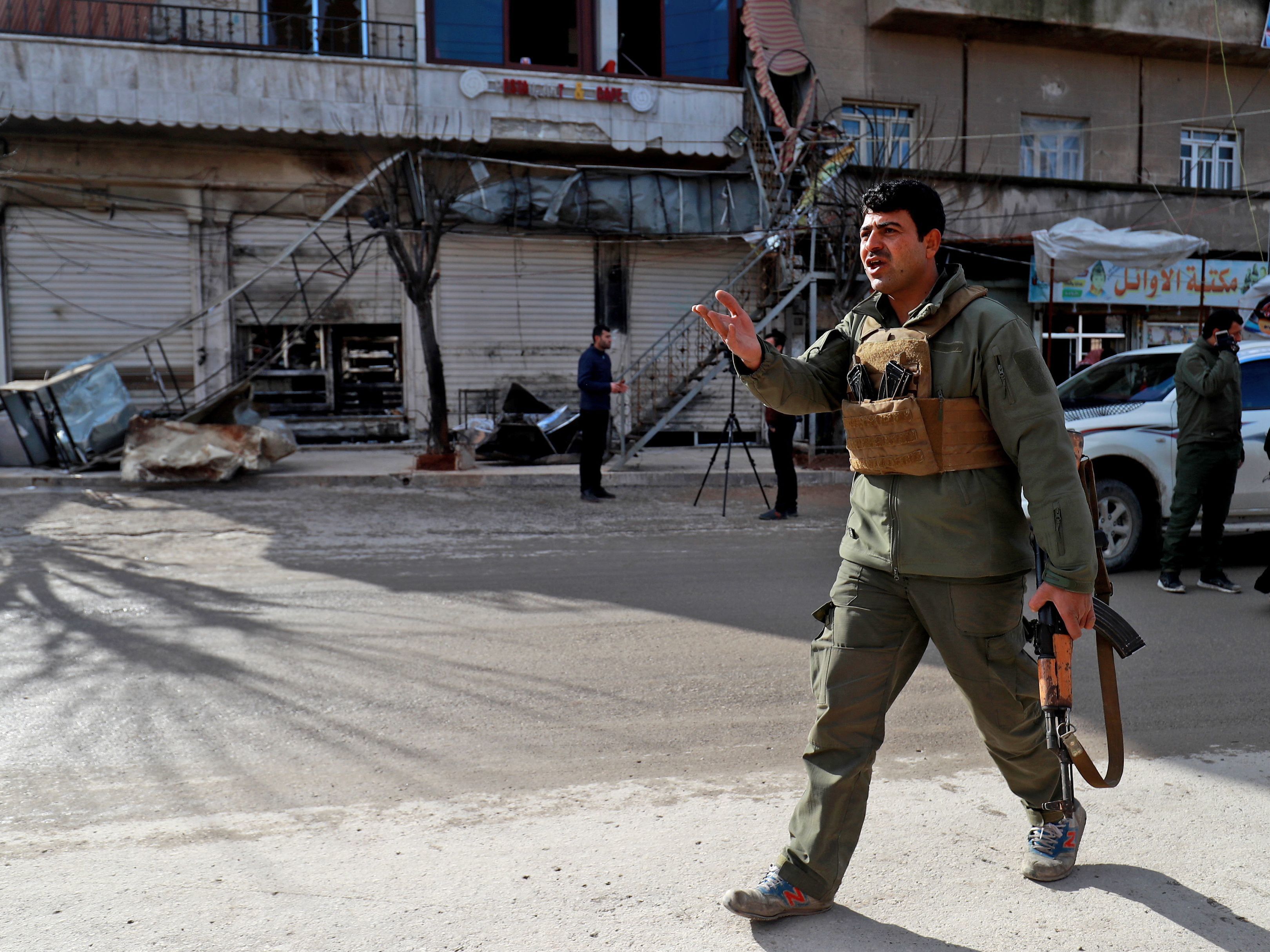 caption: A security force member walks outside a shuttered restaurant Thursday in Manbij, Syria, the site of a suicide attack that killed more than a dozen people, including four Americans, a day earlier. The Islamic State claimed responsibility for the attack.