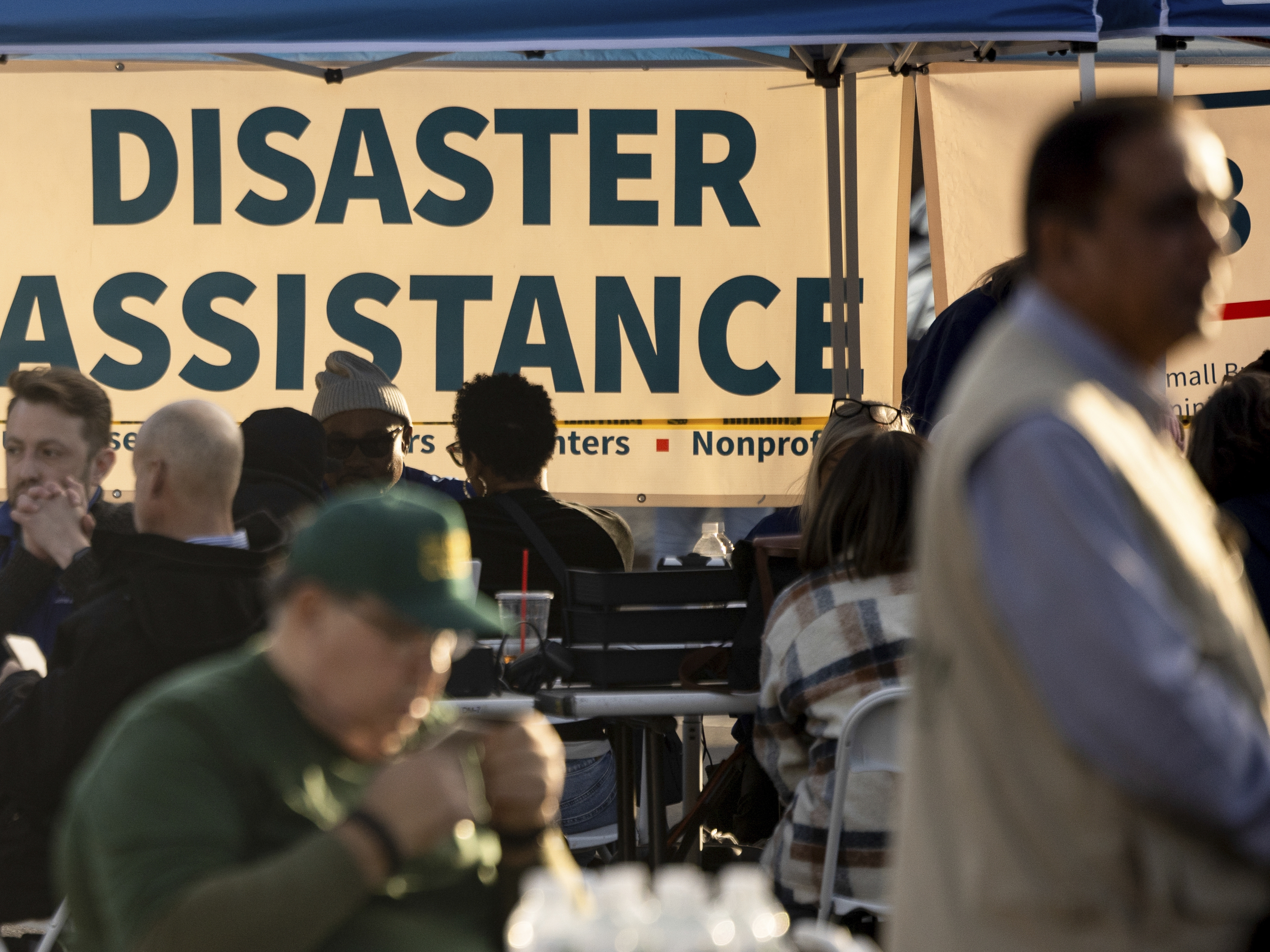 caption: People impacted by the wildfires seek information and relief at a FEMA Disaster Recovery Center in 2025, in Pasadena, Calif. The leader of FEMA's top disaster response coordination office has resigned, as President Trump moves to eliminate the agency.