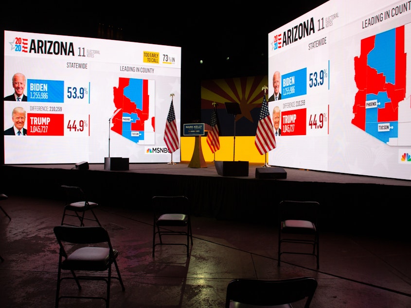 caption: Arizona presidential election results from MSNBC are displayed during Democratic Senate candidate Mark Kelly's Nov. 3 election-night event in Tucson, Ariz. Like many other news organizations, NBC held off on calling Arizona for Joe Biden, while The Associated Press called it in the early hours of Nov. 4.