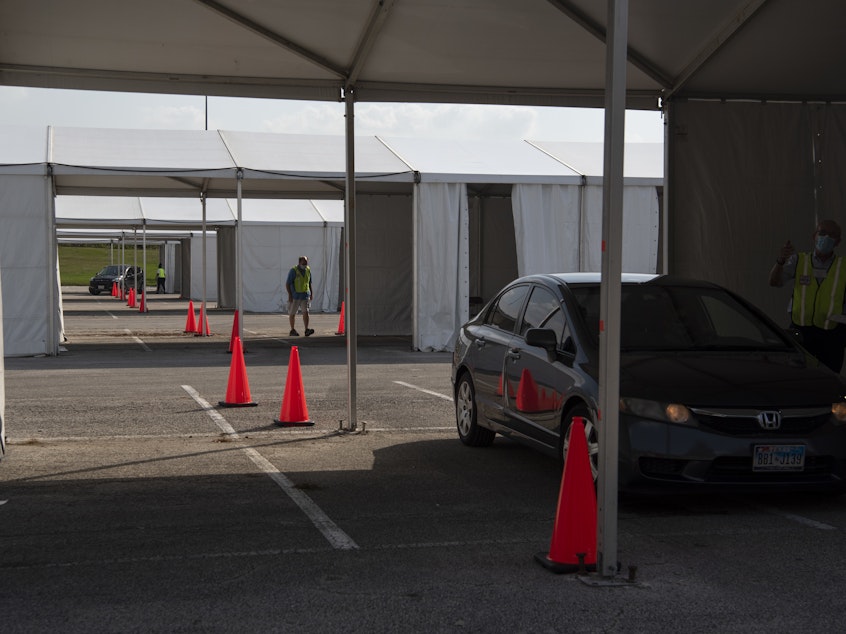 caption: Voters drop off mail-in ballots last month at a drive-through polling place in Houston. Some 127,000 voters cast their ballots at drive-through locations in the Houston area.