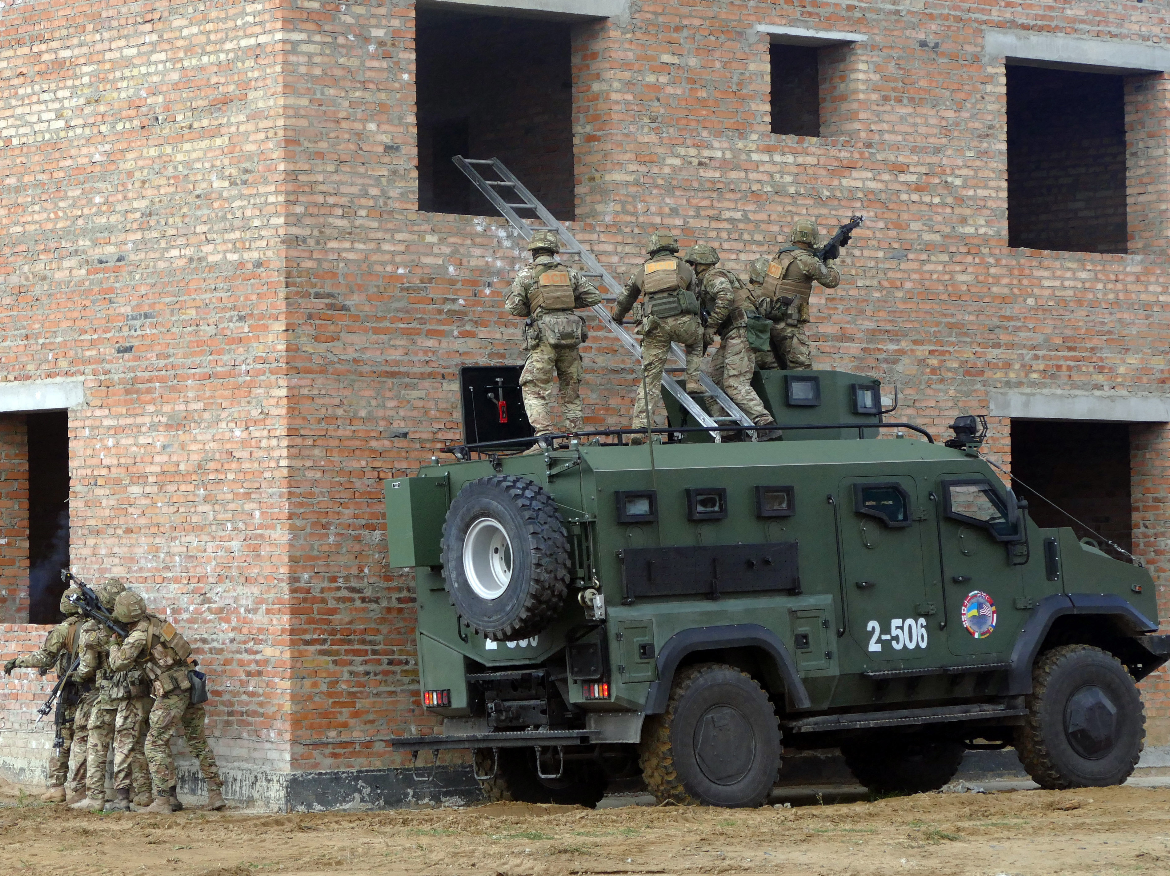 caption: Soldiers storm a building during a drill held as part of the Exercise Rapid Trident 2019, an annual multinational training exercise near Yavoriv, Ukraine.