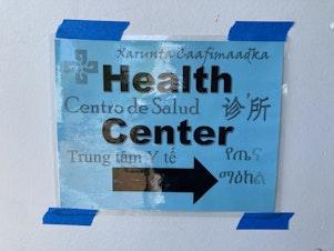 caption: A sign directs students at the Seattle World School to the building's health clinic