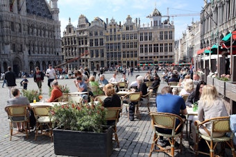 caption: People enjoy the May sunshine from the cafe terraces of Brussels' Grand Place. On Friday, European Union added the United States to the list of countries whose citizens and residents should be allowed to travel freely within the bloc.