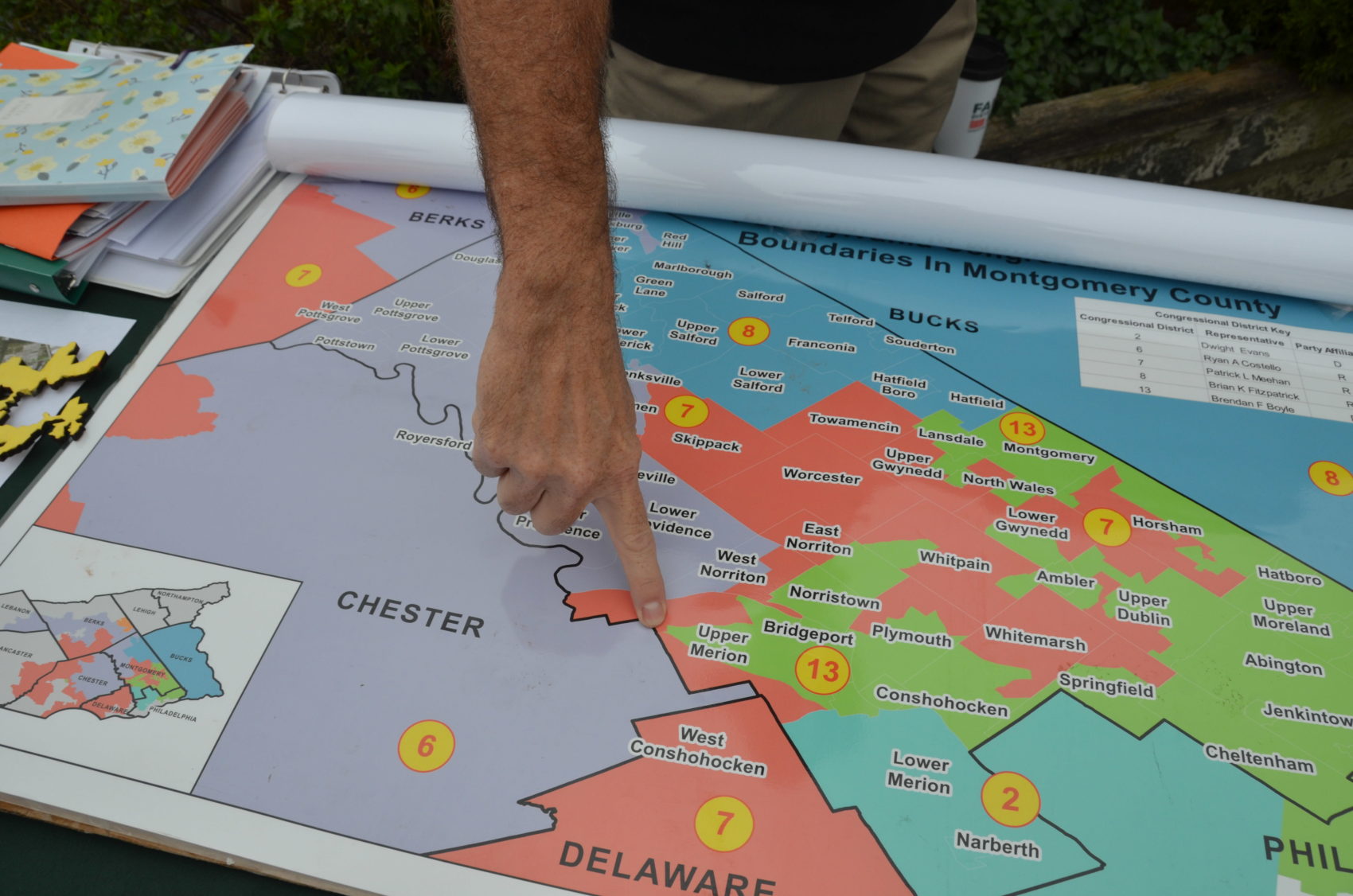 caption: Fair Districts PA organizer Rich Rafferty points to a spot in the old PA-07 in Montgomery County. The district was just as wide as a restaurant parking lot at that point on the map. The old PA-07 was considered a poster child for gerrymandering. (Alex Schroeder/On Point)