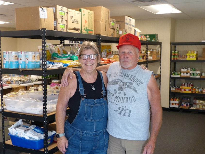 Two Malden residents, Laurie (on left) Bob Law (right), in the food bank 