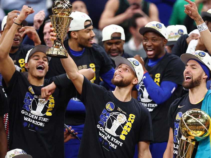 caption: Stephen Curry raises the NBA Finals Most Valuable Player Award after the Golden State Warriors defeated the Boston Celtics 103-90 in Game 6 of the 2022 NBA Finals on June 16, 2022 in Boston.