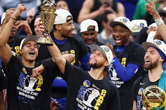 caption: Stephen Curry raises the NBA Finals Most Valuable Player Award after the Golden State Warriors defeated the Boston Celtics 103-90 in Game 6 of the 2022 NBA Finals on June 16, 2022 in Boston.