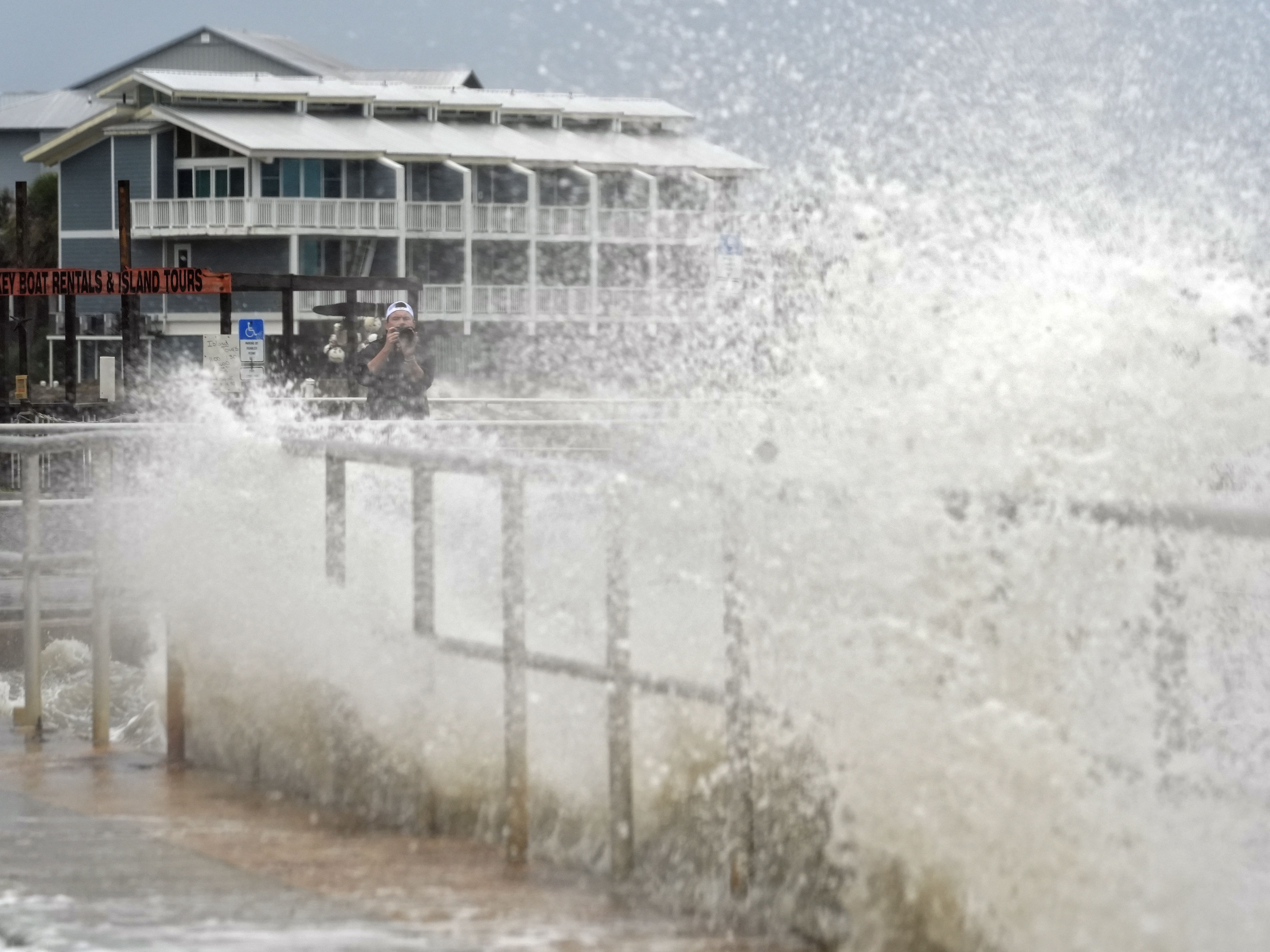 caption: Surf from Tropical Storm Debby breaks over a sea wall in Cedar Key, Fla., in August 2024. Abnormally hot ocean water is contributing to a very active Atlantic Hurricane season. Climate change is the main driver of record-breaking ocean temperatures, but scientists are trying to figure out what other causes may be at play.