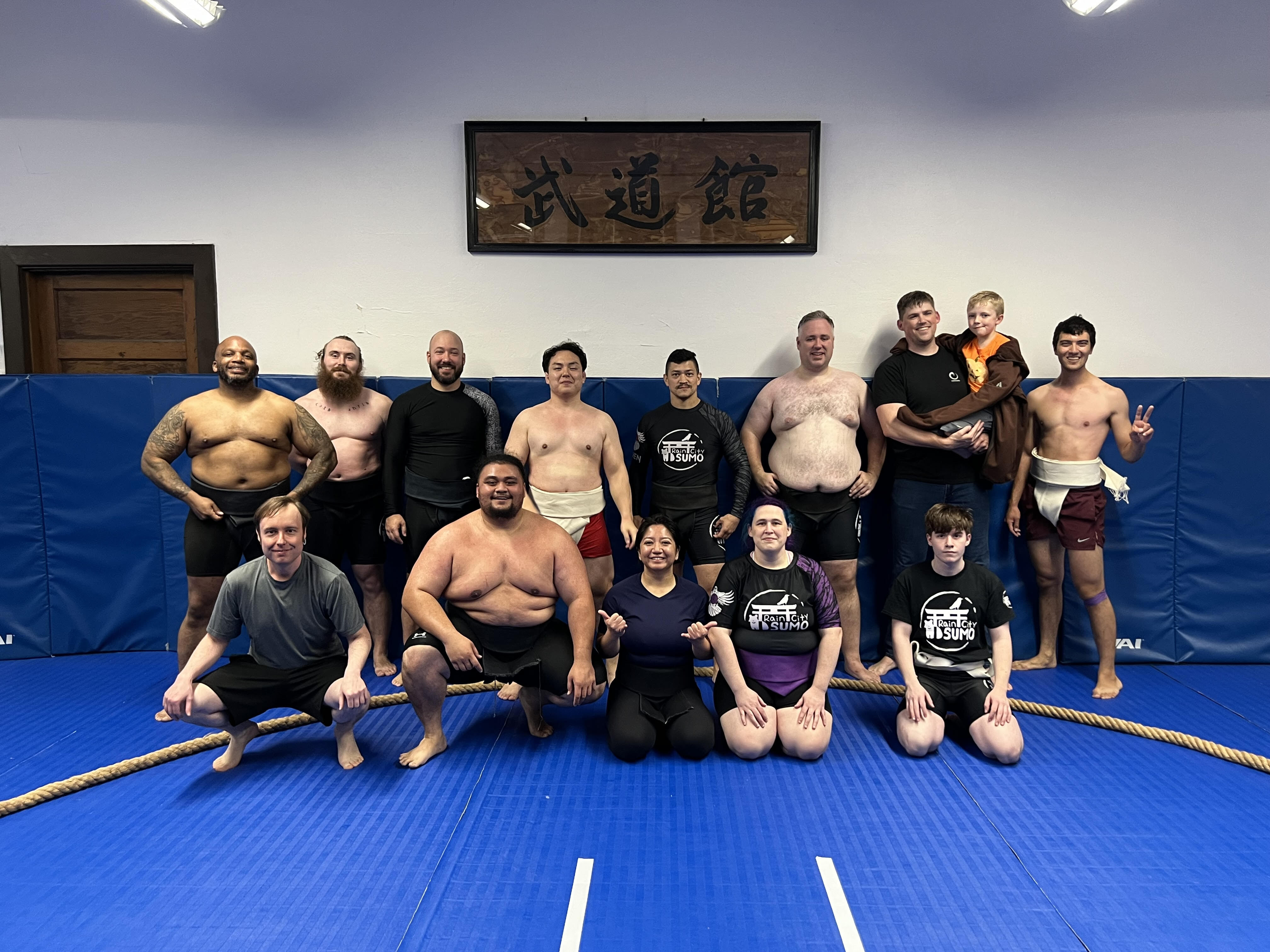 caption: A group of Rain City Sumo wrestlers pose for a photo.