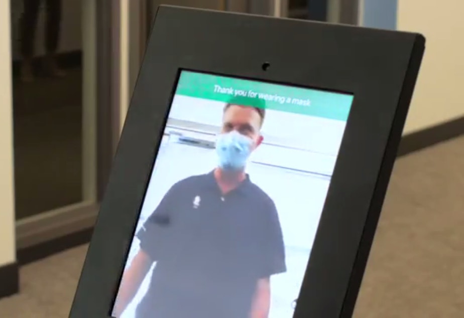 caption: Screen grab from a Nomad Go demo video showing a kiosk that monitors mask compliance at a building entry.