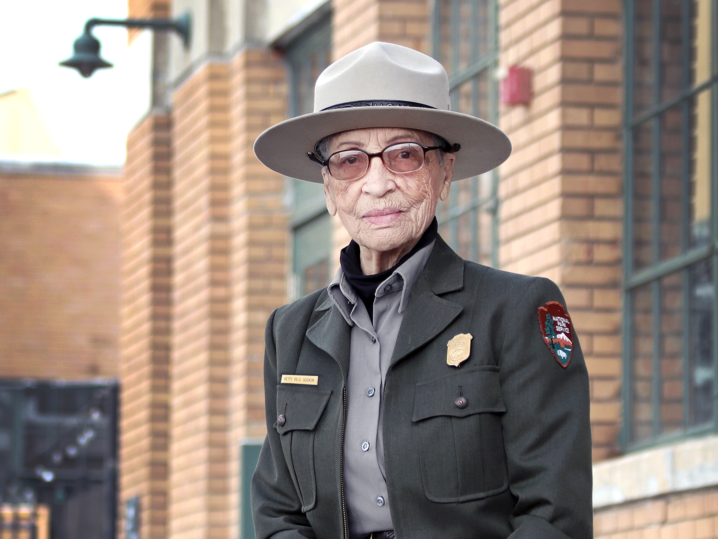 caption: Ranger Betty Reid Soskin sits in front of the Rosie the Riveter/WWII Home Front National Historical Park Visitor Education Center. Soskin is celebrating her 100th birthday, serving as the nation's oldest National Park Service ranger.