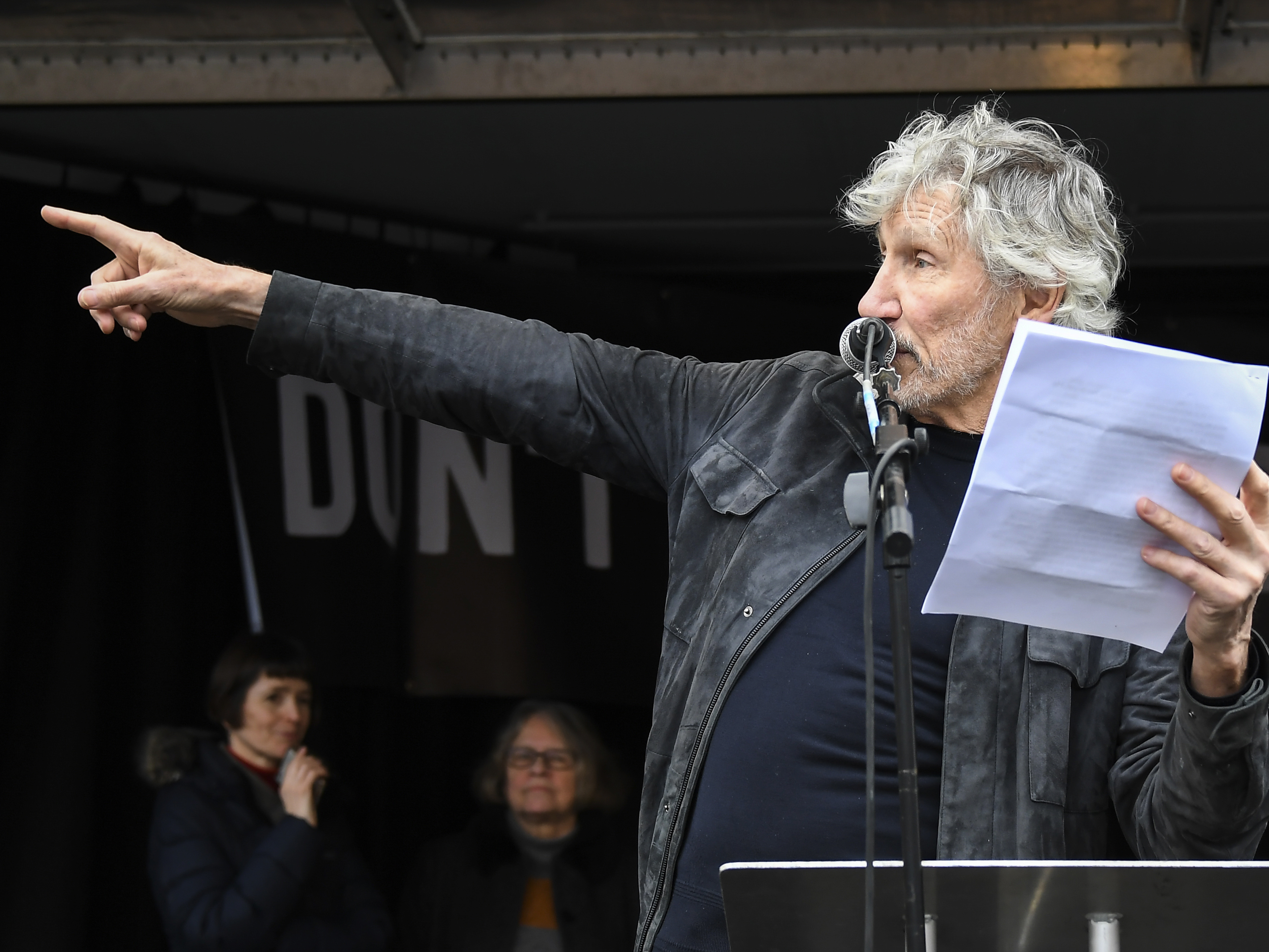 caption: British musician Roger Waters speaks at a rally in Parliament Square, London, as part of the demonstration against the extradition of Julian Assange on Saturday.