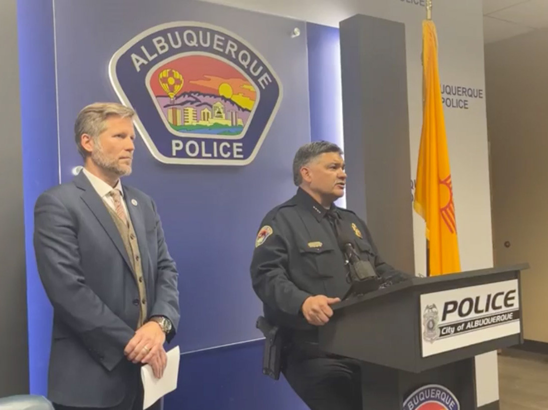 caption: "We're worried and concerned that these are connected and possibly politically motivated or personally motivated," Albuquerque Mayor Tim Keller, left, said of a string of shootings. He's seen here alongside Police Chief Harold Medina during a press conference via the Albuquerque Police Department's Facebook livestream.