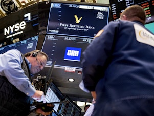 caption: Traders work on the floor at the New York Stock Exchange in New York on March 13.