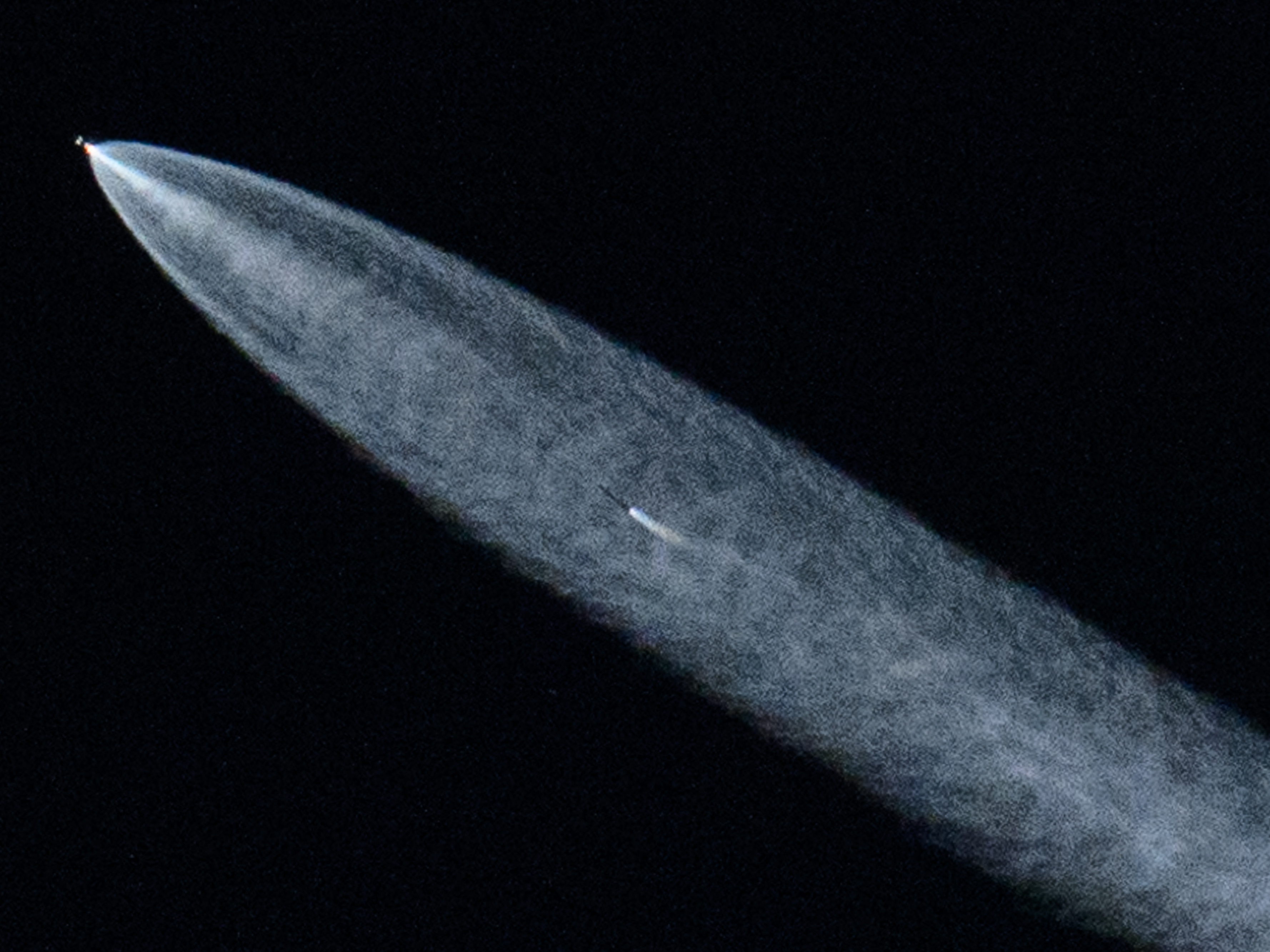 caption: A SpaceX Falcon 9 rocket with a payload of 20 Starlink satellites is seen in the evening sky above Lawndale, Calif., after being launched from Vandenberg Space Force Base on June 18, 2024.