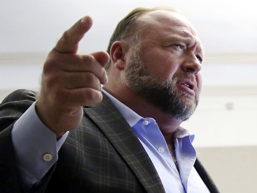 caption: Alex Jones talks to reporters during a break in his trial in Austin, Texas, on July 26.
