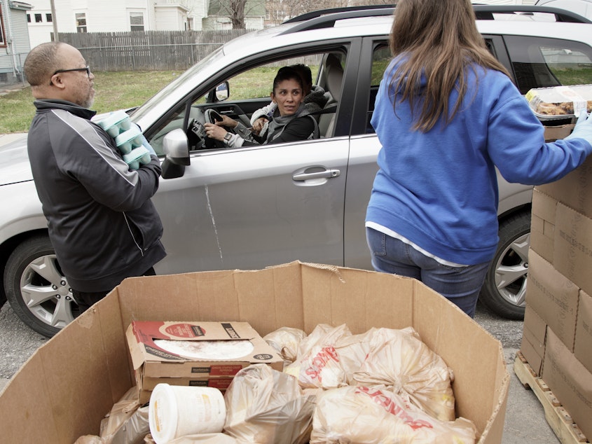 caption: Together Inc. food bank workers distribute food at a drive-through location in Omaha, Neb., last week. Disruptions in the agricultural supply chain caused by the coronavirus pandemic are making it difficult for food banks.