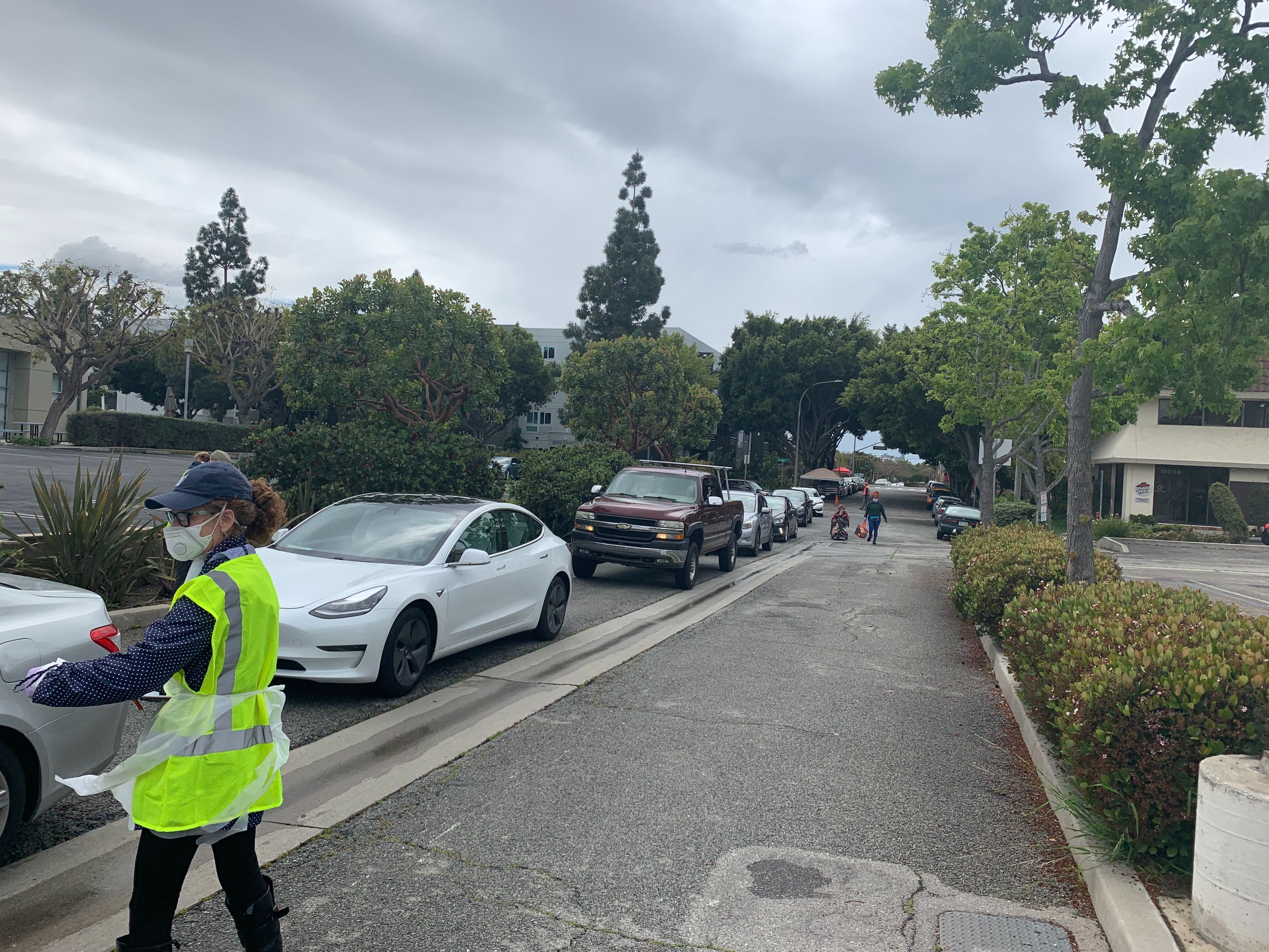 caption: A volunteer speaks to people at a pop-up test site for marginalized communities in Los Angeles County.