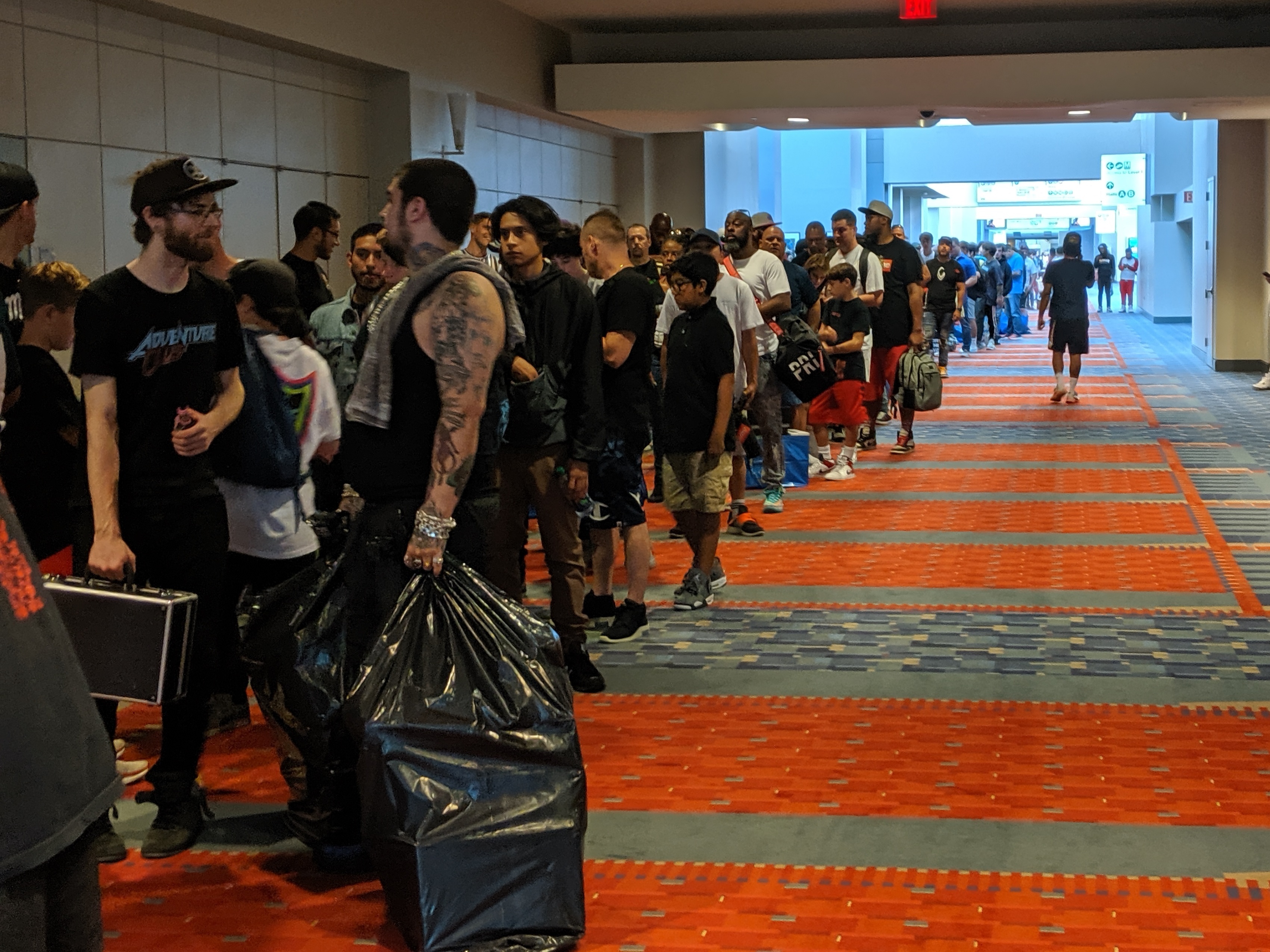 caption: The line of attendees waiting to get in stretched down the hall, up the stairs, and outside the building. Sneaker Con organizers expect more than 10,000 people to show up to the event this weekend.