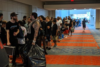 caption: The line of attendees waiting to get in stretched down the hall, up the stairs, and outside the building. Sneaker Con organizers expect more than 10,000 people to show up to the event this weekend.