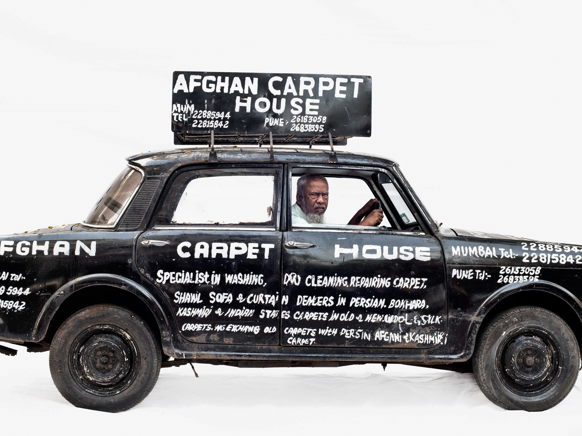 caption: Abdul's vehicle promotes his work as a carpet repair man in Mumbai, India.