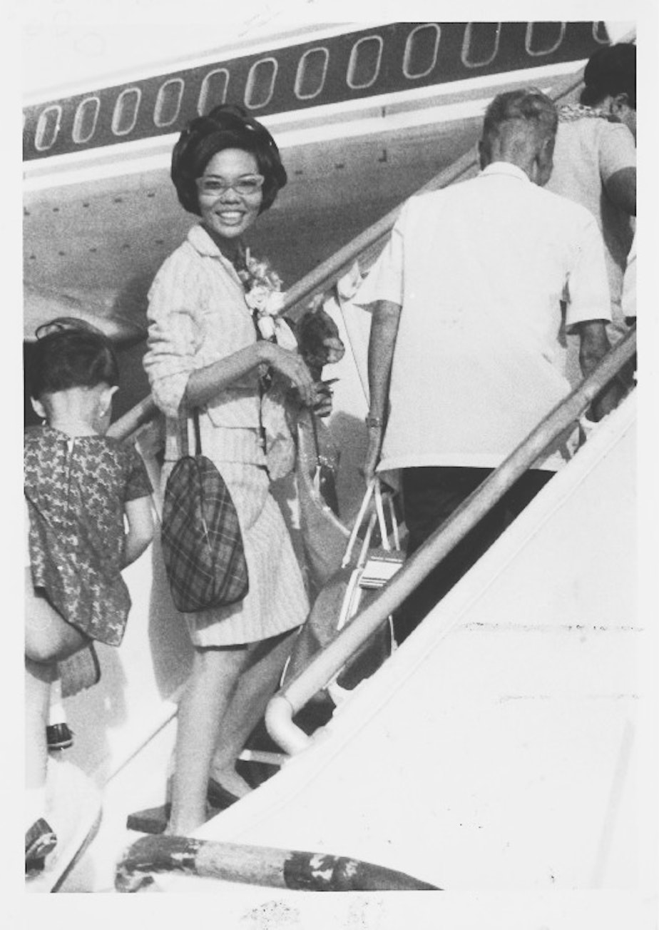 caption: Erlinda Conde boards the plane as she leaves her home in the Philippines for a new life in Chicago.