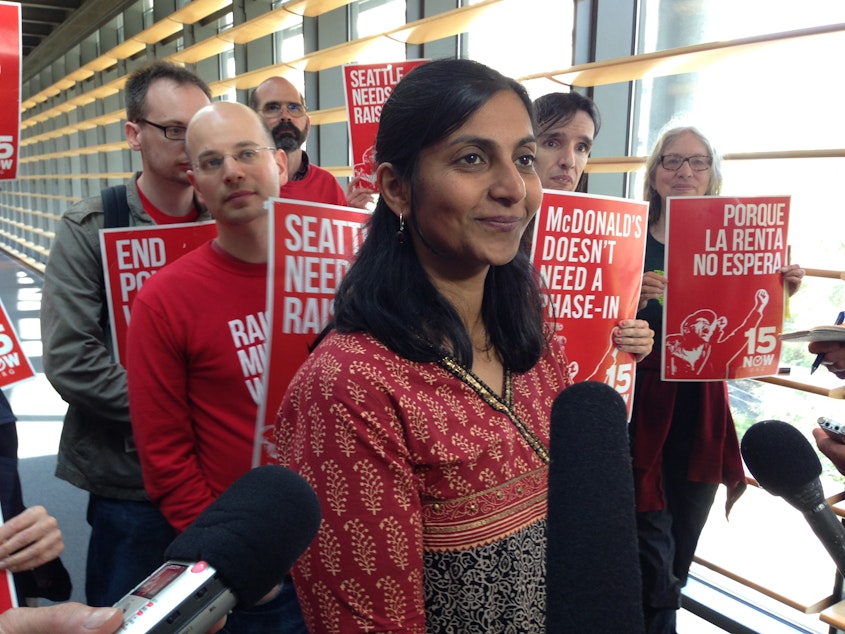 caption: Seattle City Councilmember Kshama Sawant meets with reporters after the vote to phase-in a $15 minimum wage June 3, 2014.