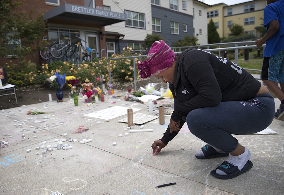 caption: Alaina Williams, a friend and neighbor of Charleena Lyles, writes, 'Love U Leena,' in chalk at a memorial for Lyles on Monday.