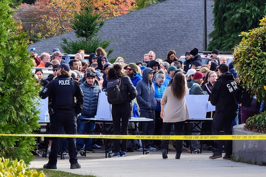 caption: Families wait outside a police line at Ingraham High School, located in the Haller Lake neighborhood of North Seattle, after a shooting was reported at the school, Nov. 8, 2022. 