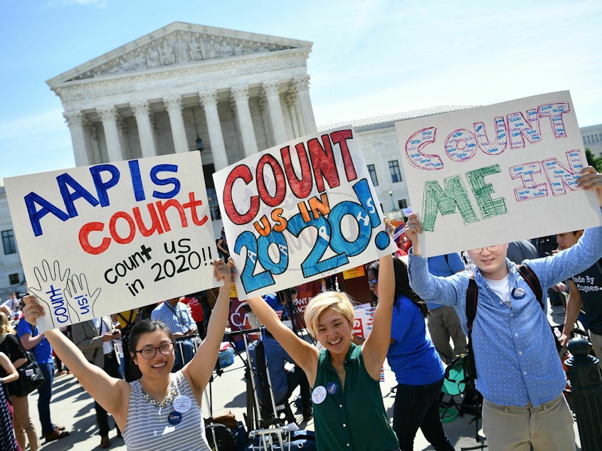 caption: Demonstrators hold signs about counting Asian Americans and Pacific Islanders in the U.S. census during a 2019 protest outside the Supreme Court in Washington, D.C., against the failed push to add a citizenship question by former President Donald Trump's administration.